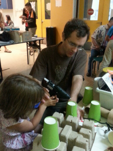 Father and Daughter using the hot glue gun to glue junk together.