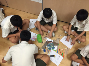 Grup boys trying out paper circuit