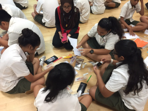 Teacher joins in together with the students to make paper circuit